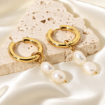 gold hoops and baroque pearls on stone