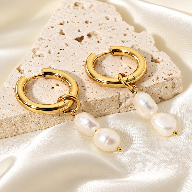 gold hoops and baroque pearls on stone