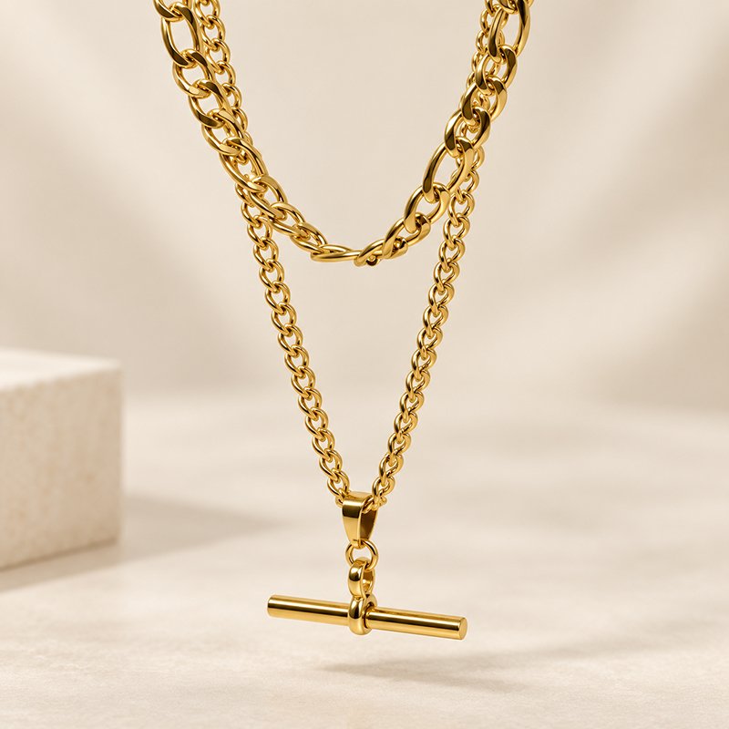 layered gold necklace on cream backdrop